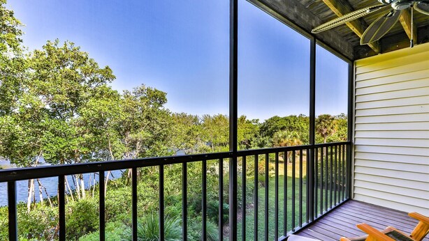 A balcony with a view of a lake and surrounding greenery. - LAKE PALMS 7 - Newly Updated Sanibel Condo Overlooking Lagoon (Sanibel)