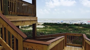 Een houten terras met uitzicht op het strand en de oceaan.