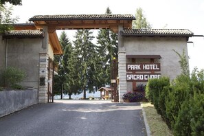 The entrance to Park Hotel in Sadowa Churae, featuring a traditional wooden archway and a signboard.