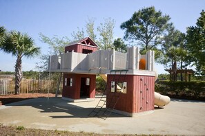 Un parque infantil con tobogán y estructura de escalada.