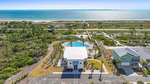 A coastal property with a swimming pool, a guesthouse, and a view of the ocean. - The Heron Beach House in Windmark / Mexico Beach, 2 Pools & 5 min walk to Beach. (Port St Joe)