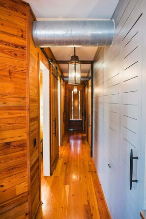 Stylish hallway leads to a door with a pendant light overhead.