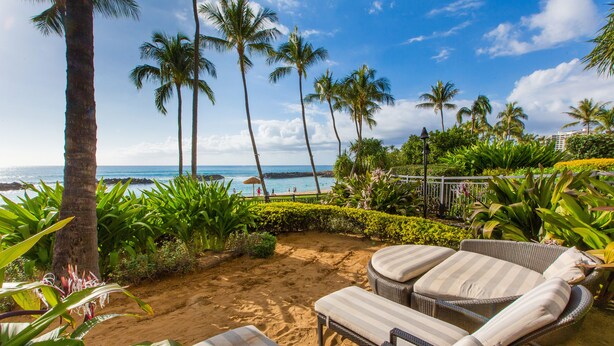 A beachside patio with wicker lounge chairs and a view of the ocean. - Luxurious Beach Villa 3BR/2.5B in KoOlina~FREE WIFI, GYM w/ ALL NEW UPGRADES (Kapolei)