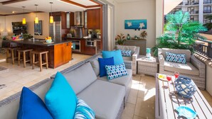 A modern living area with a kitchen, dining space, and a balcony with outdoor furniture. - Luxurious Beach Villa 3BR/2.5B in KoOlina~FREE WIFI, GYM w/ ALL NEW UPGRADES (Kapolei)