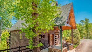 A log cabin with a porch, a stone bench, and a sign indicating it is a campground. - Luxury Cabin, Casino, Ski, Snow Tube, Golf, Hike, Fish, Hot Tub, Fire Pit, Train (Whittier)