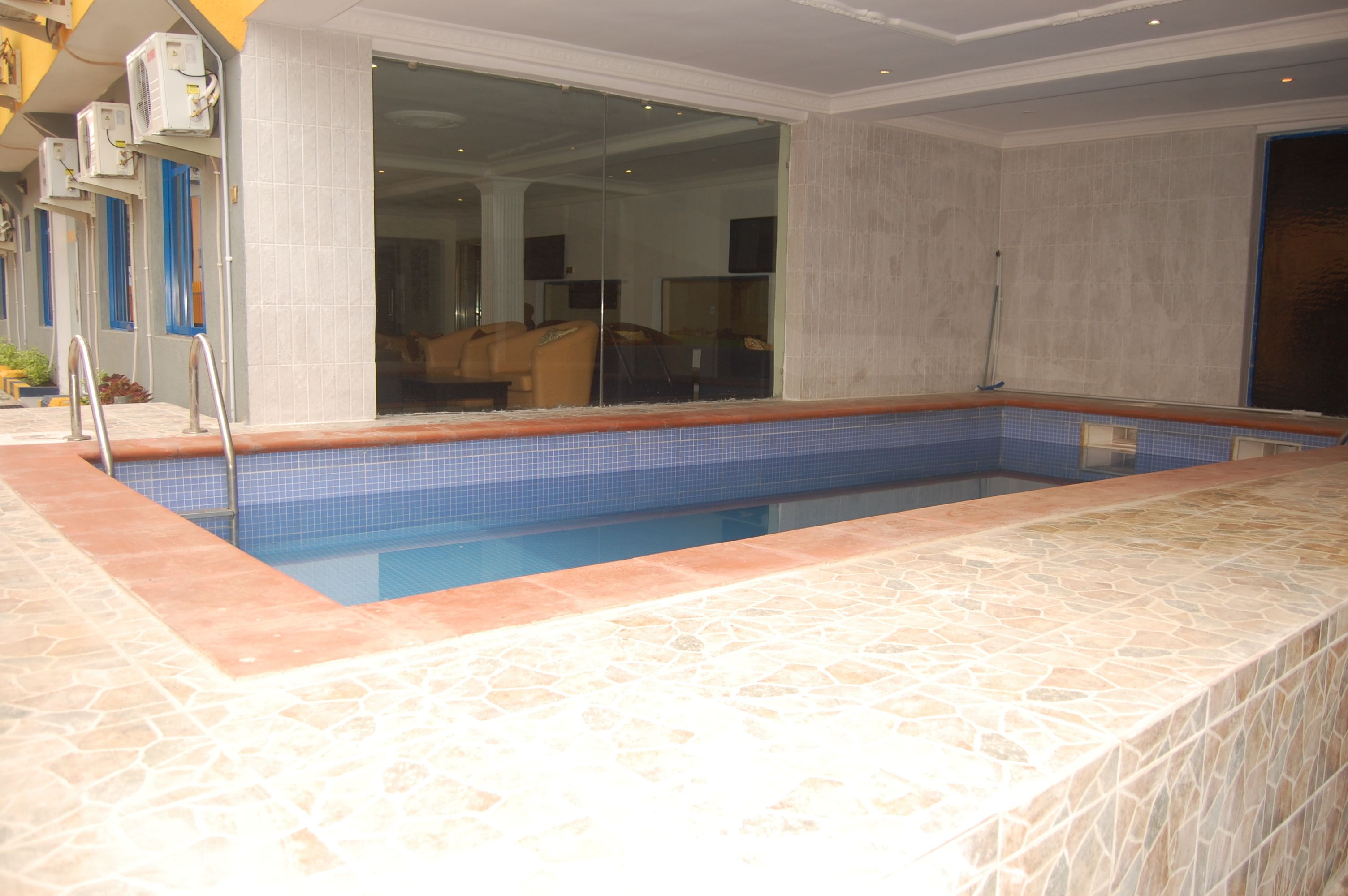 Una piscina con borde de azulejos y contorno de piedra.