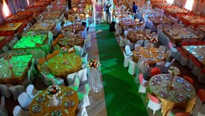 A banquet hall with round tables, white chairs, and a stage in the background. - BEN AUTO guest house (Lagos)