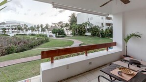Un balcone con vista su un giardino curato e edifici sullo sfondo.