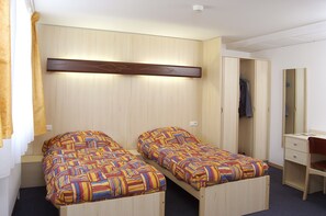 A room with two single beds, a wooden wardrobe, a desk with a chair, and a mirror. - Centre Le Mittel (Mittelwihr)