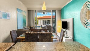 Ein Hotelzimmer mit Essbereich, einer Sitzecke, einem Fernseher und Blick ins Freie.