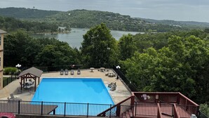 Une piscine avec vue sur un lac et des collines.