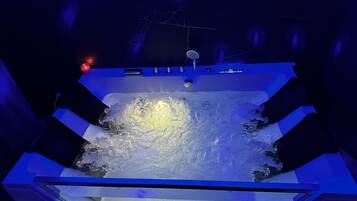 Ein Whirlpool mit Wasserstrahlen, einer Steuerung und einer Deckenleuchte.