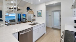Una cocina moderna con una isla grande, electrodomésticos integrados y vistas al exterior.