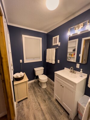 A bathroom with a toilet, sink, and vanity. - Welcome to your home away from home! (Beattyville)