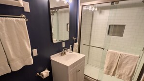 Un baño moderno con inodoro, lavabo y ducha.