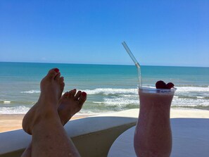 Uitzicht op het strand met een tafel en twee drankjes.