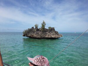 A small rocky island surrounded by clear turquoise water. - Appartement (Grand-Baie)