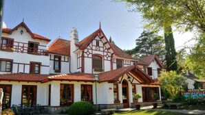 A traditional European-style building with a symmetrical facade, multiple windows, and a well-maintained lawn. - L'Hirondelle - Adults Only (La Falda)