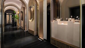 Un moderno vestíbulo de hotel con un diseño elegante, que presenta un largo pasillo con techos abovedados y un mostrador de recepción de estética minimalista.
