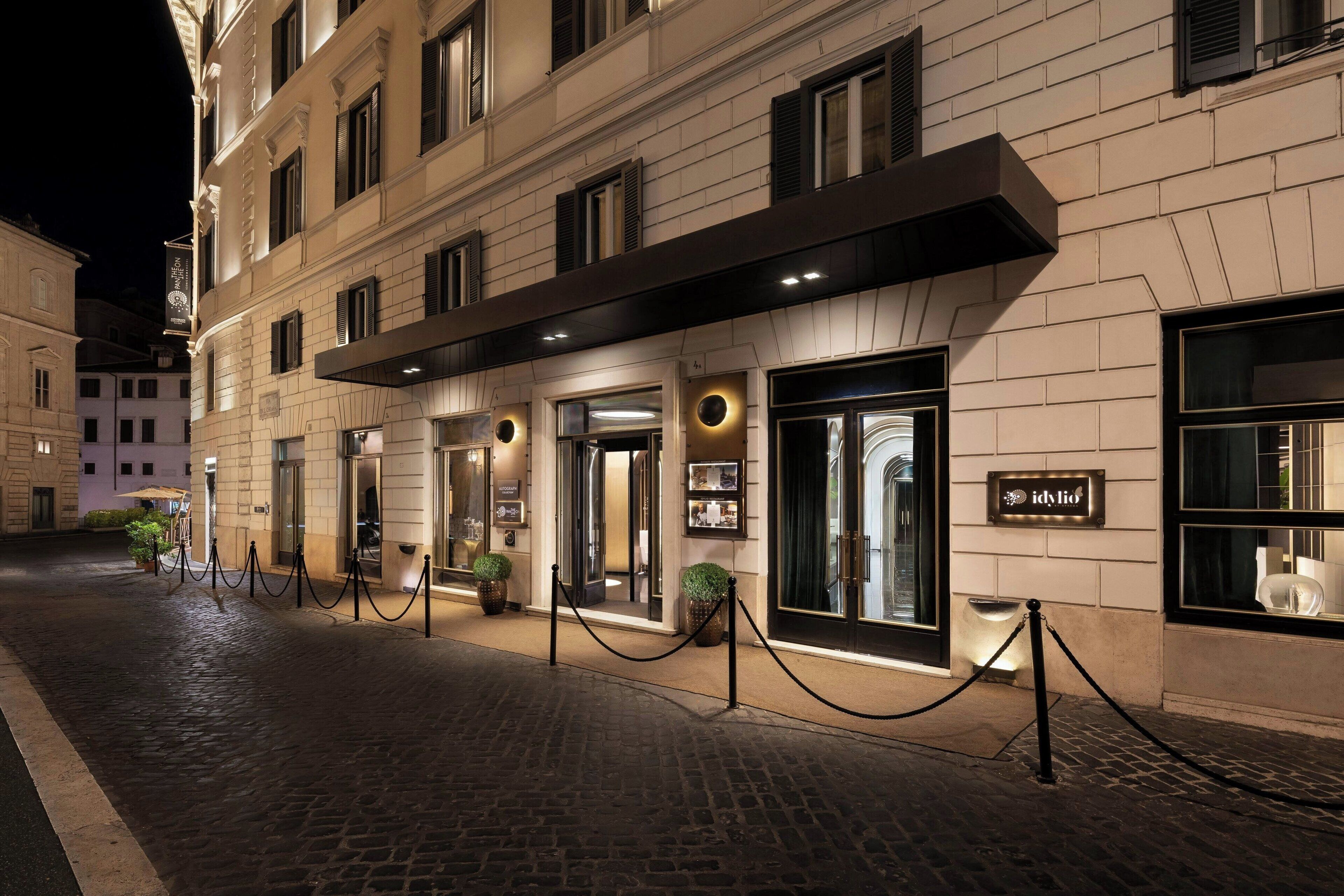 A hotel entrance with a dark awning, glass doors, and a sign for 'idvlio'.