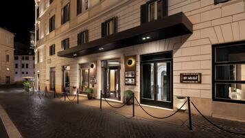 A hotel entrance with a dark awning, glass doors, and a sign for 'idvlio'.