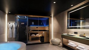 Un baño moderno con una bañera grande, cabina de ducha con mampara de vidrio y tocador con espejo.
