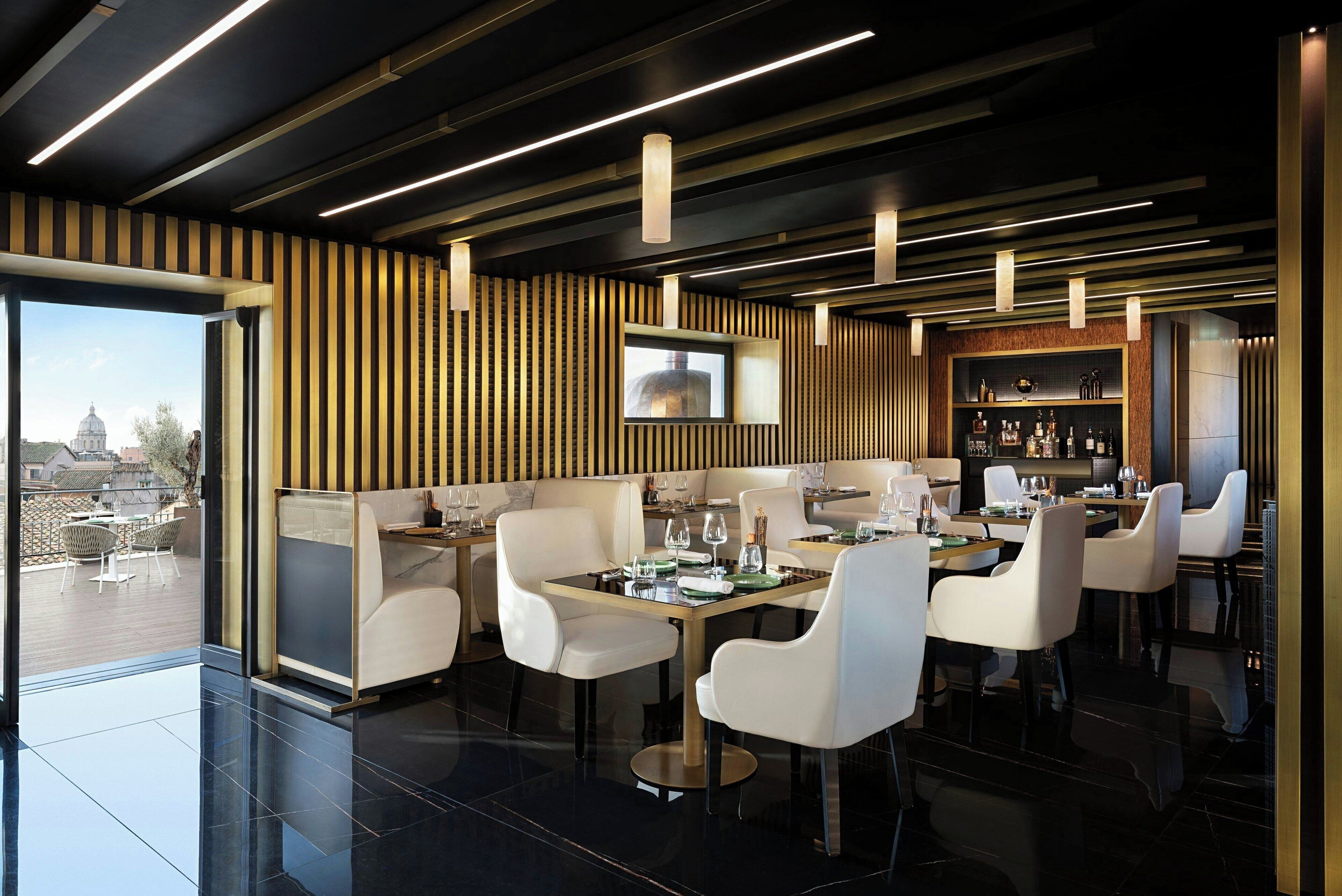 Un espace de restauration moderne doté d’un bar, de grandes fenêtres et offrant une vue sur le paysage urbain.