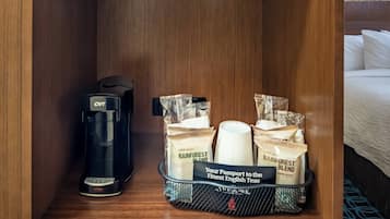 Et hotelværelse med kaffemaskine, en kurv med teposer og et skilt, der siger "Dit pas til de fineste engelske teer."