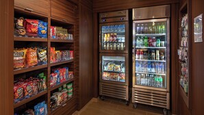 Ein Automatenbereich mit Snacks und Getränken, darunter verschiedene Pauschalangebote und abgefüllte Getränke.