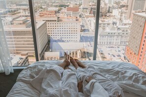 A bed with a city view through large windows. - JW Marriott Nashville (Nashville)