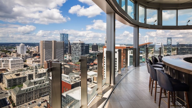 Un edificio alto con vistas panorámicas de la ciudad desde un balcón.