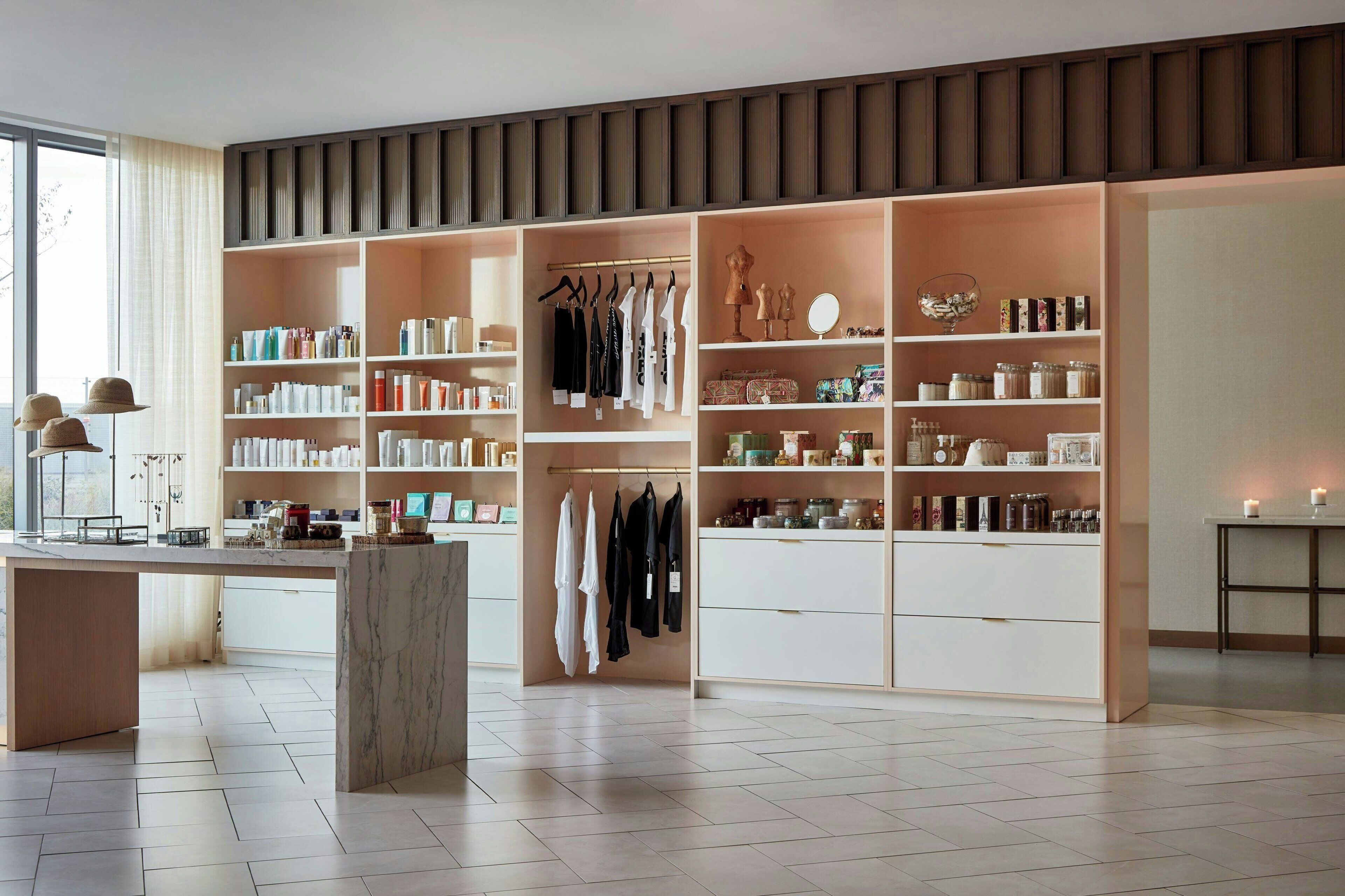 A modern, well-organized room with built-in shelving for books, clothes, and storage containers.