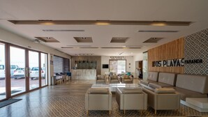 A modern hotel lobby with a reception desk, seating area, and a view of parked cars outside. - Dos Playas by Faranda All Inclusive (Cancun)