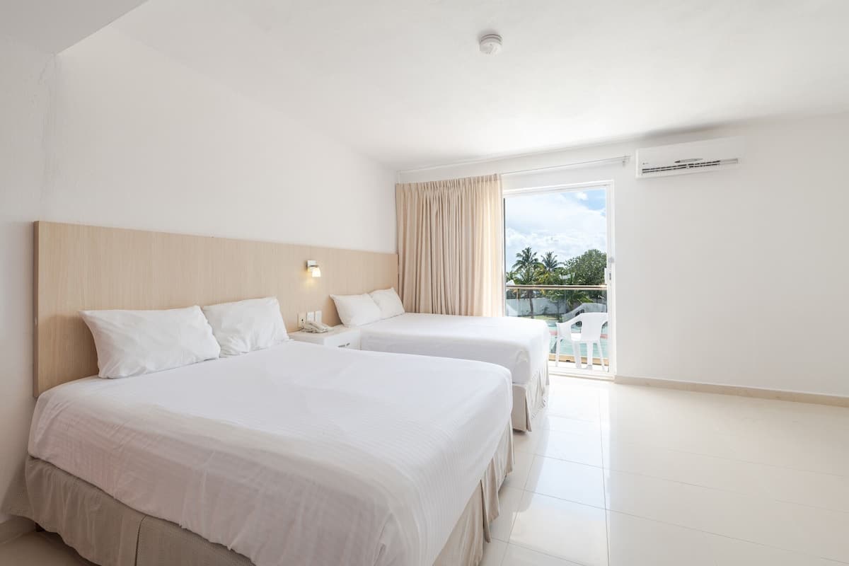 A hotel room with two beds, a large window, and a balcony.