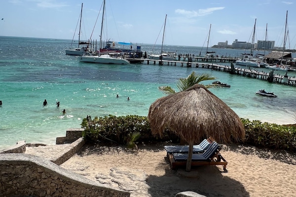 On the beach, white sand, sun loungers, beach umbrellas