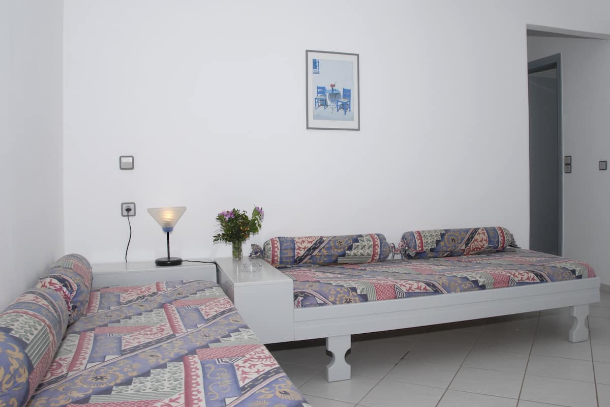 A modern bedroom with a large bed, a bedside table with a lamp, and a framed picture on the wall.