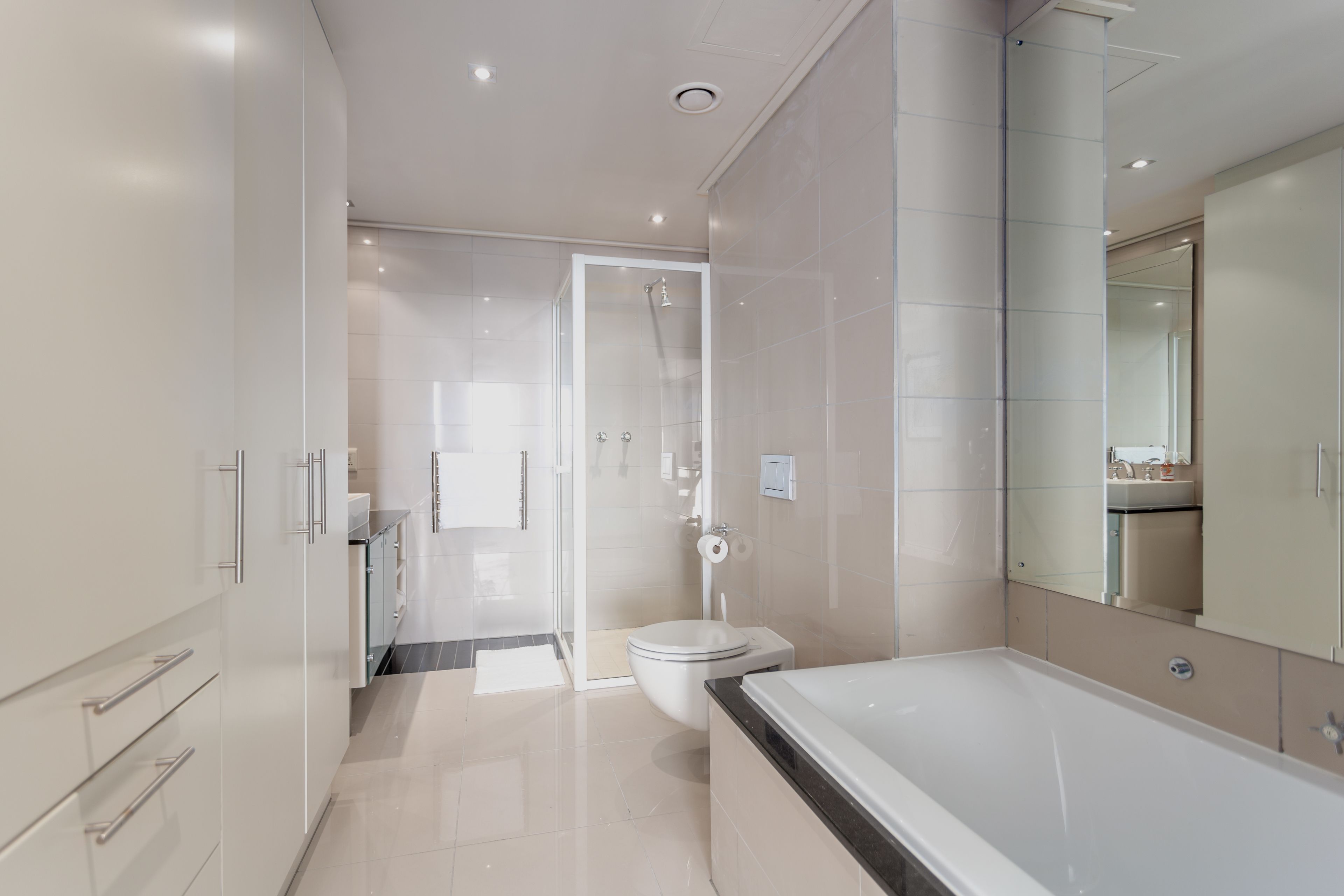 A modern bathroom with a bathtub, toilet, and shower area.