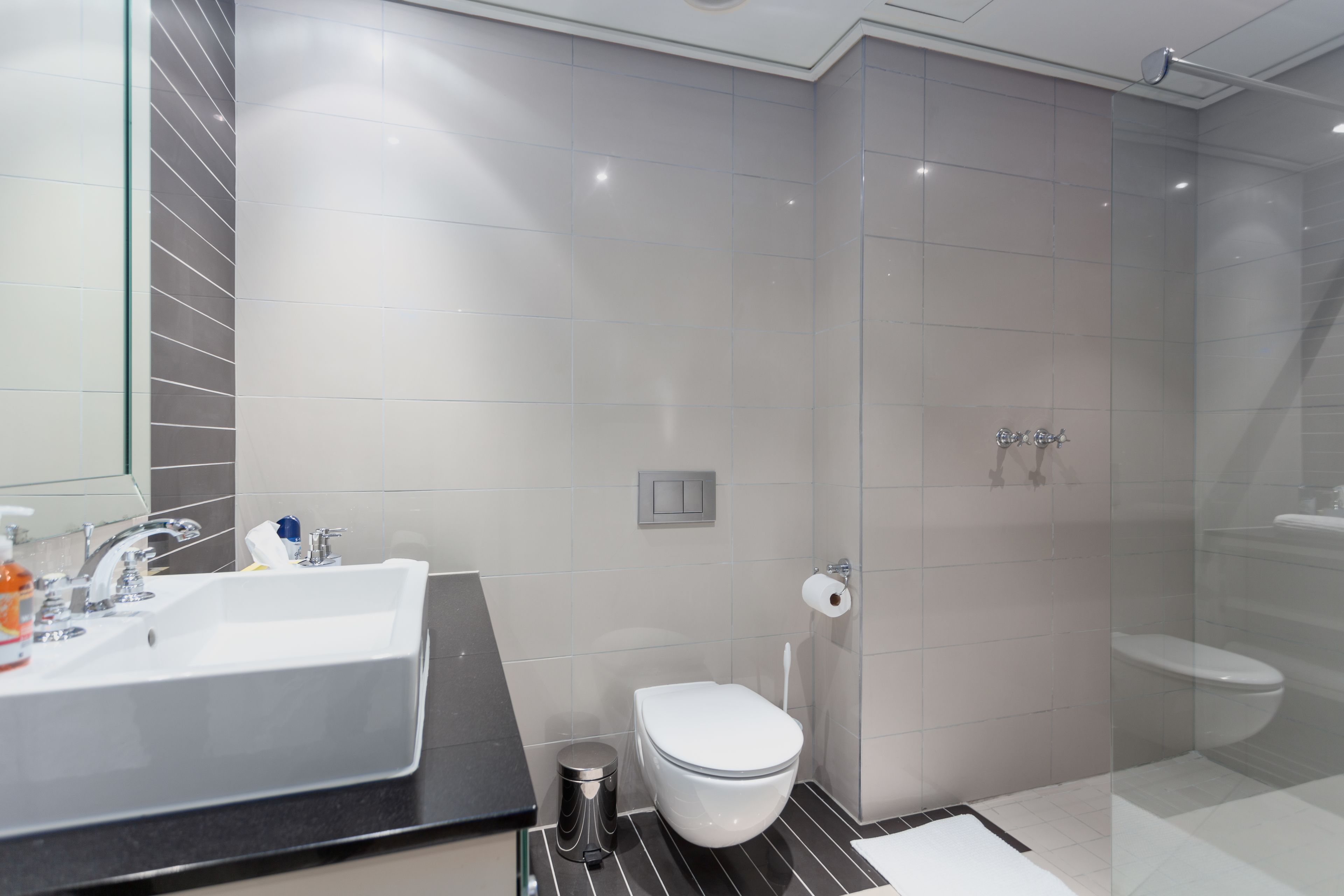 Un baño moderno con un lavamanos grande, inodoro y zona de ducha.