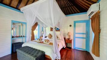 Un dormitorio con cama con dosel, una mesita de noche, un banco y una puerta.