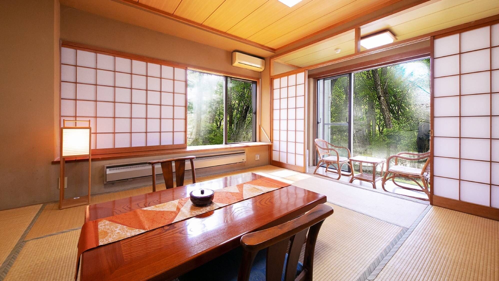 A traditional Japanese room with tatami flooring, a low table, and sliding doors.