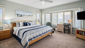 A bedroom with a bed, desk, chair, and a ceiling fan. - Cedars East Bayview Tennis & Pool Unit 822 by RVA (Longboat Key)