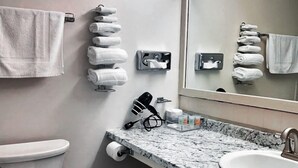 A modern bathroom with a toilet, sink, and towel rack. - Newport Motel (Newport)