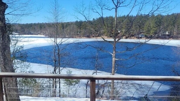 Une terrasse offrant une vue sur un lac gelé et les arbres environnants.