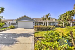 A modern two-story house with a garage, surrounded by lush tropical landscaping. - Solar-Heated Pool! Tropical Apollo Beach Hideaway (Apollo Beach)