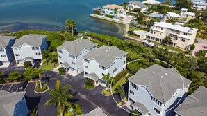 A coastal residential area with multiple two-story houses, a marina, and a clear view of the ocean.