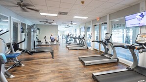A gym with treadmills, exercise bikes, and weight machines. - Courtside Getaway – Cedars East #605 by RVA (Longboat Key)