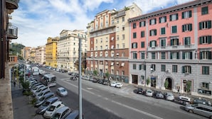 Vista d'un carrer amb cotxes aparcats, edificis i cel serè.
