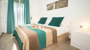 A neatly arranged bedroom with a bed, a bedside table, and a wall-mounted lamp. - 2 Bedroom Apartment- Ona Aucanada Alcudia, Mallorca (Aucanada, Puerto de Alcudia, Illes Balears)
