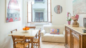 A dining area with a wooden table, chairs, a bench, and a decorative vase with flowers. - APPARTAMENT IN THE CITY CENTER OF FLORENCE (Firenze)