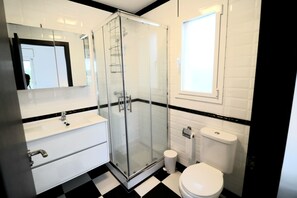 Een bad/douchecombinatie, een haardroger, handdoeken